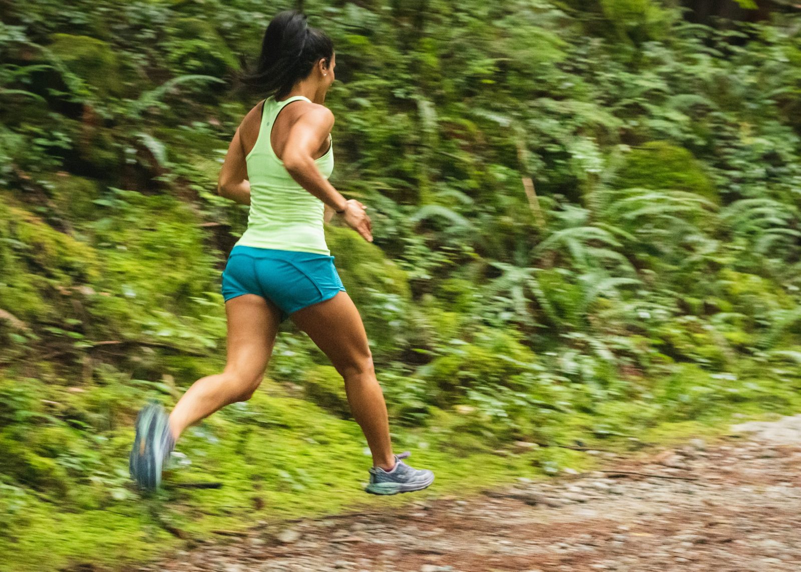 A woman running a forest trail