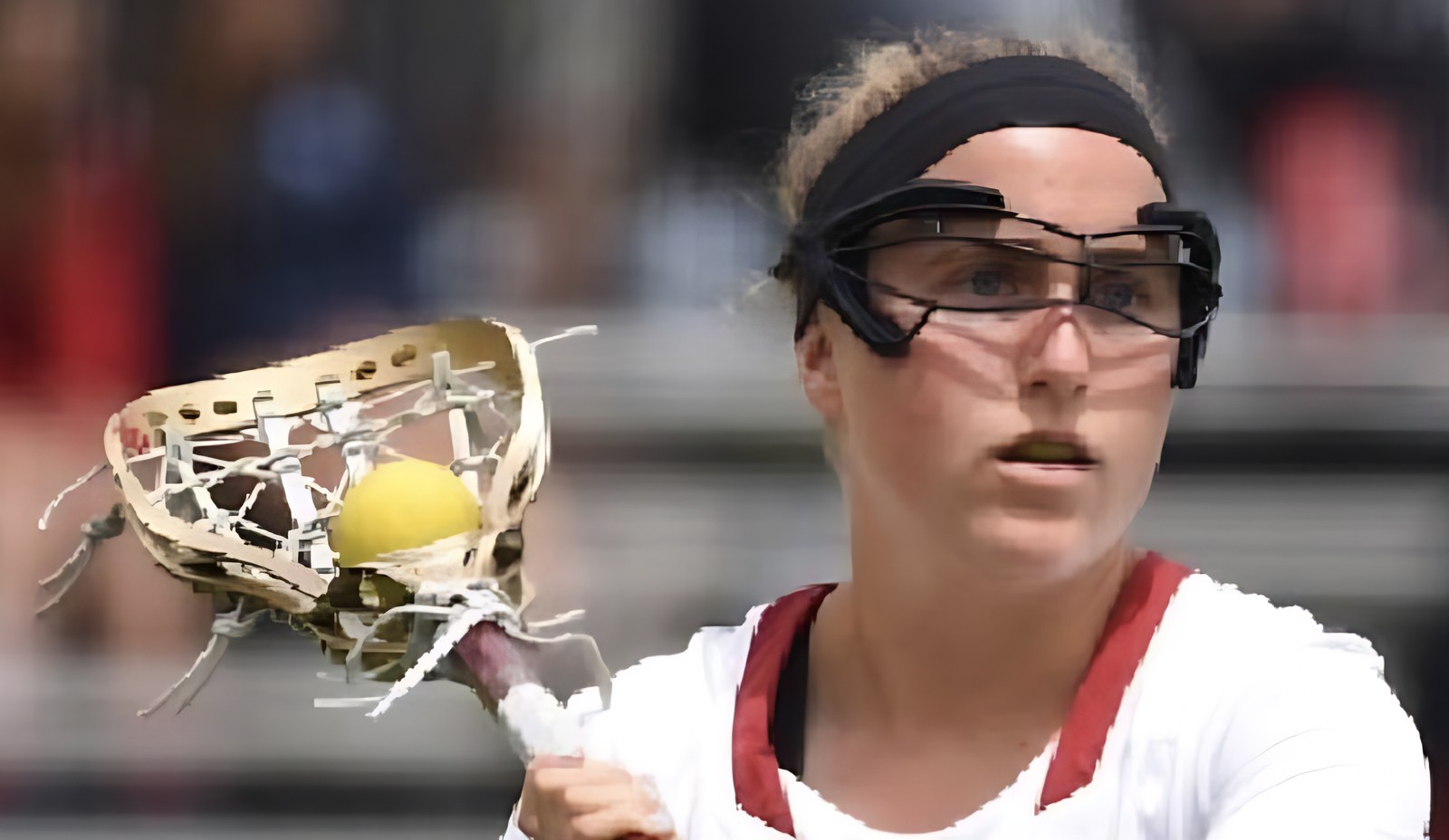 A lacrosse player cradling the ball, eyes up the field