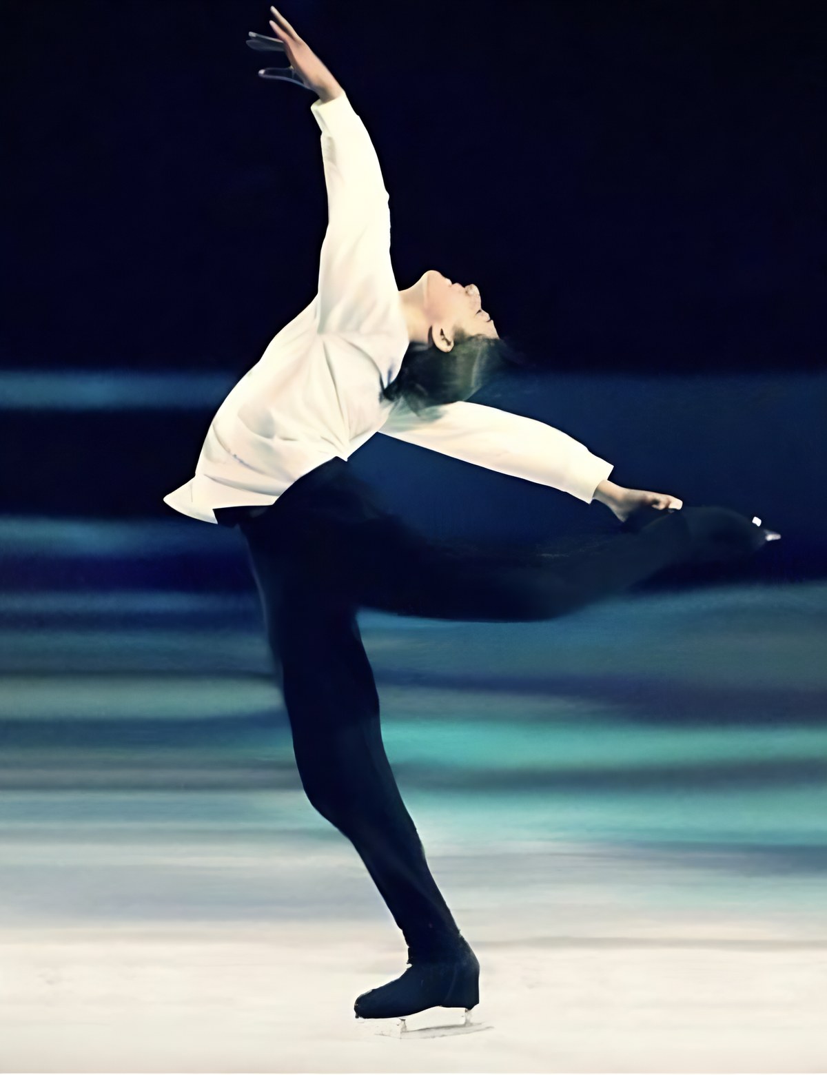 A figure skater in a soaring arabesque under show lights